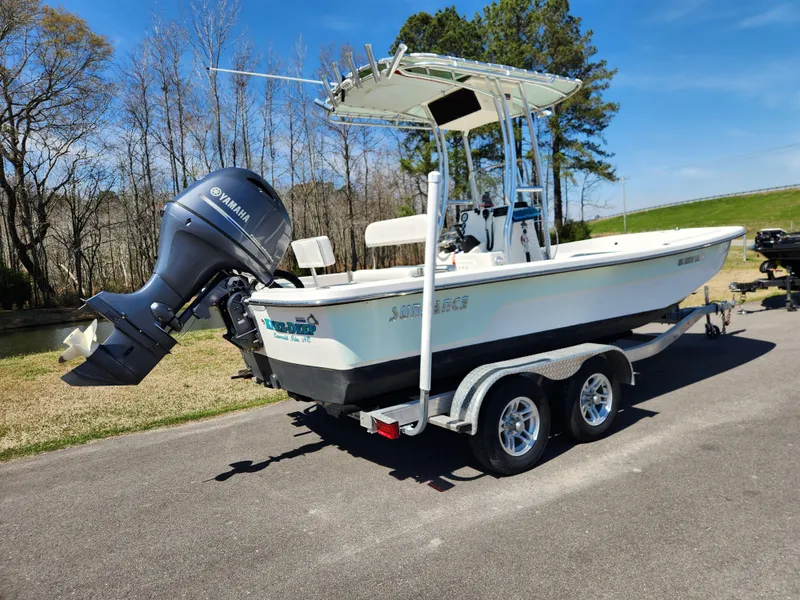 Slide: The Image of 2015 Sundance B20CCR boat on trailer with Yamaha outboard motor, parked on a sunny day. - 2