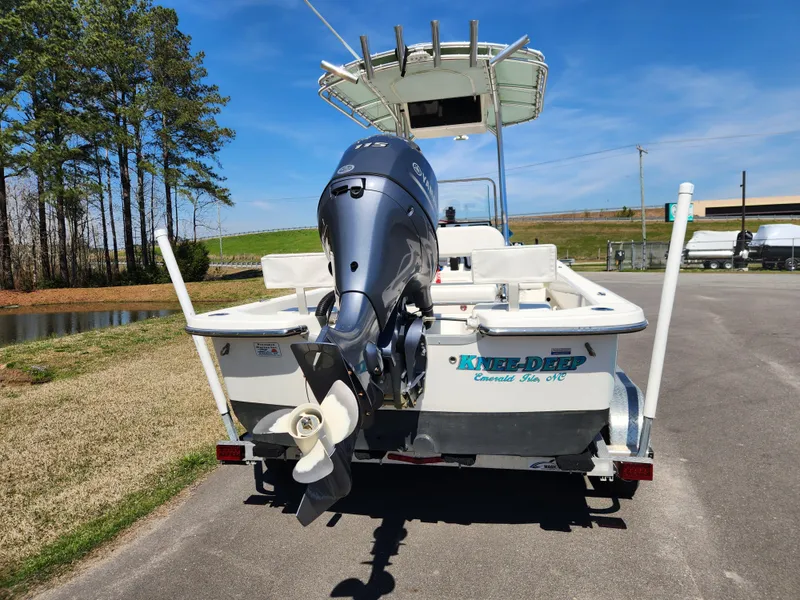 Slide: The Image of Sundance B20CCR 2015 boat with outboard motor on a trailer, parked near a pond. - 3