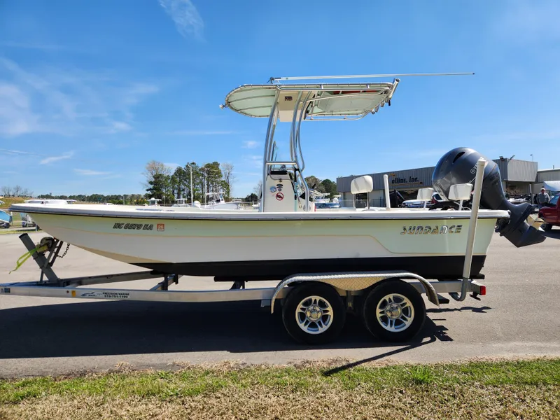 Slide: The Image of 2015 Sundance B20CCR boat on trailer, parked outdoors under clear blue sky. - 6