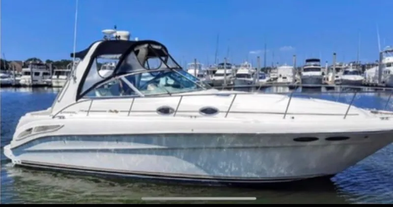 Slide: The Image of 2000 Sea Ray 340 Sundancer boat docked in a marina under clear blue skies. - 0