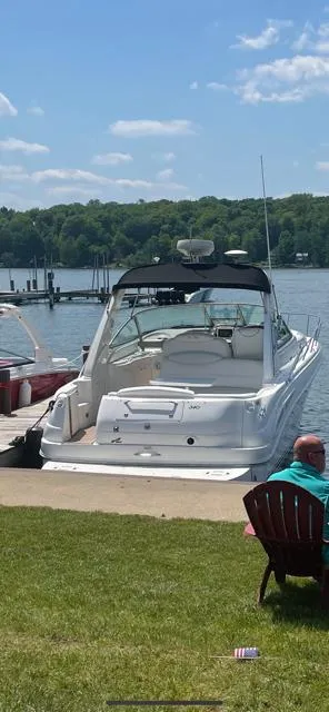 Slide: The Image of 2000 Sea Ray 340 Sundancer docked by a scenic lake with lush greenery. - 10