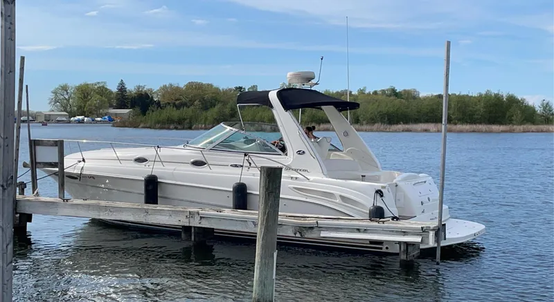 Slide: The Image of 2000 Sea Ray 340 Sundancer docked on a calm lake with trees in the background. - 2
