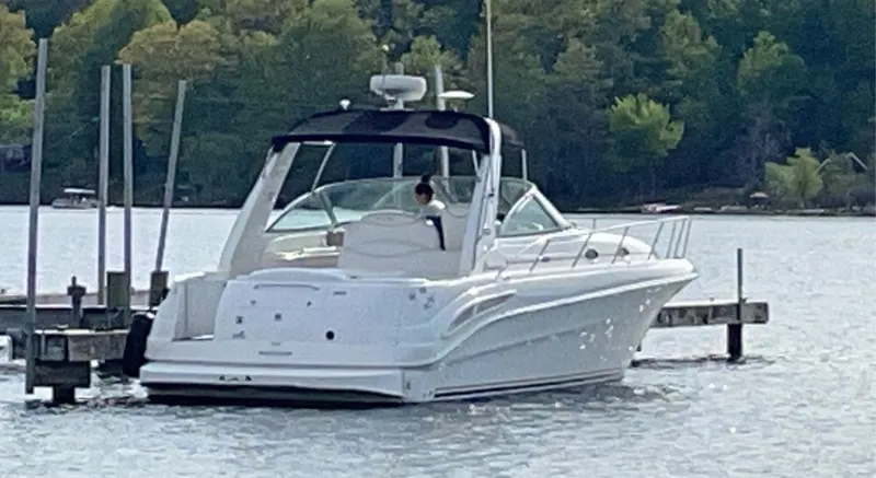 Slide: The Image of 2000 Sea Ray 340 Sundancer docked on a serene lake with lush green trees. - 3