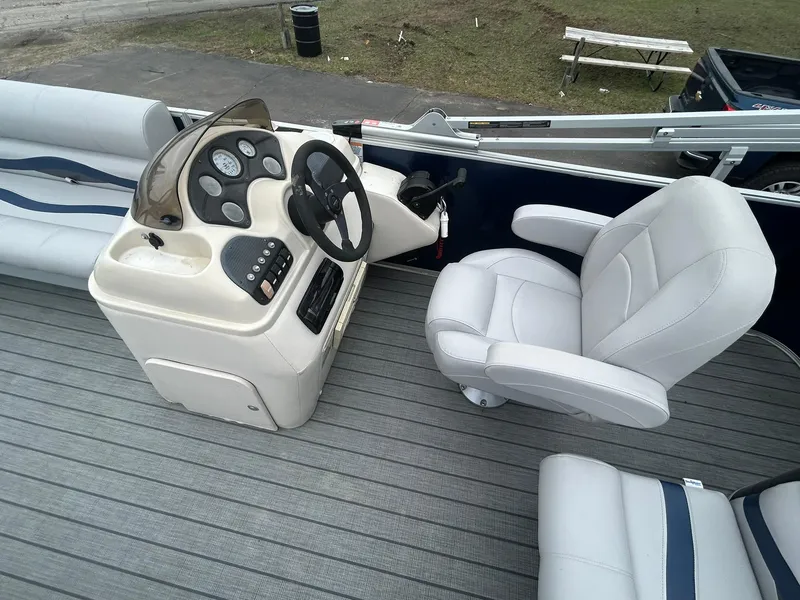 Slide: The Image of 1999 Sylvan 20 Cruise boat interior with steering console and cushioned seating. - 8