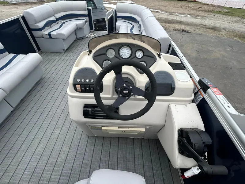 Slide: The Image of 1999 Sylvan 20 Cruise boat interior with steering console and cushioned seating. - 9