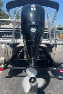 Slide: The Image of 2023 Sun Tracker SportFish 22 DLX pontoon boat with outboard motor, rear view. - 2