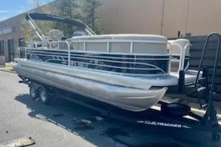 Slide: The Image of 2023 Sun Tracker SportFish 22 DLX pontoon boat on trailer, parked outdoors. - 3