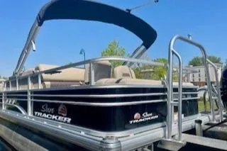 Slide: The Image of 2023 Sun Tracker SportFish 22 DLX pontoon boat with canopy, docked outdoors. - 6