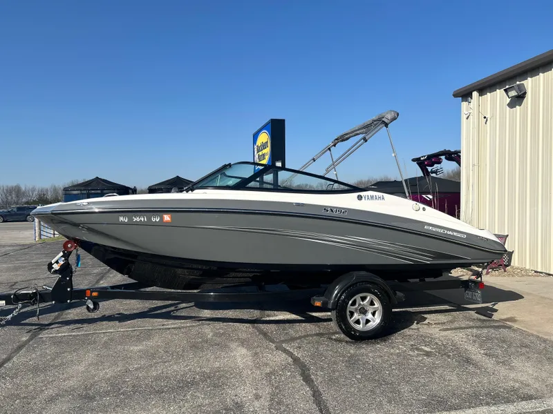 Slide: The Image of 2015 Yamaha SX192 boat on trailer, parked outdoors under clear blue sky. - 5