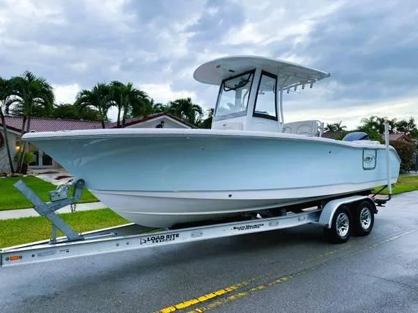 Slide: The Image of 2021 Sea Hunt Ultra 255 SE boat on trailer, parked on a residential street. - 0
