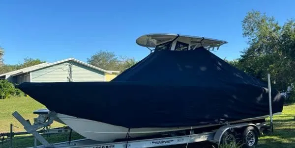 Slide: The Image of 2021 Sea Hunt Ultra 255 SE boat covered on a trailer in a yard. - 12