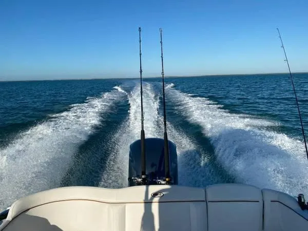 Slide: The Image of 2021 Sea Hunt Ultra 255 SE boat cruising on open water with fishing rods. - 7