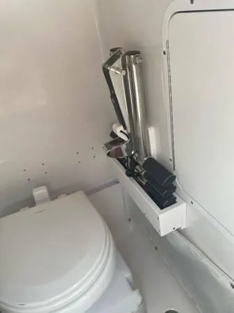 Slide: The Image of 2021 Sea Hunt Ultra 255 SE boat bathroom with toilet and storage compartment. - 9