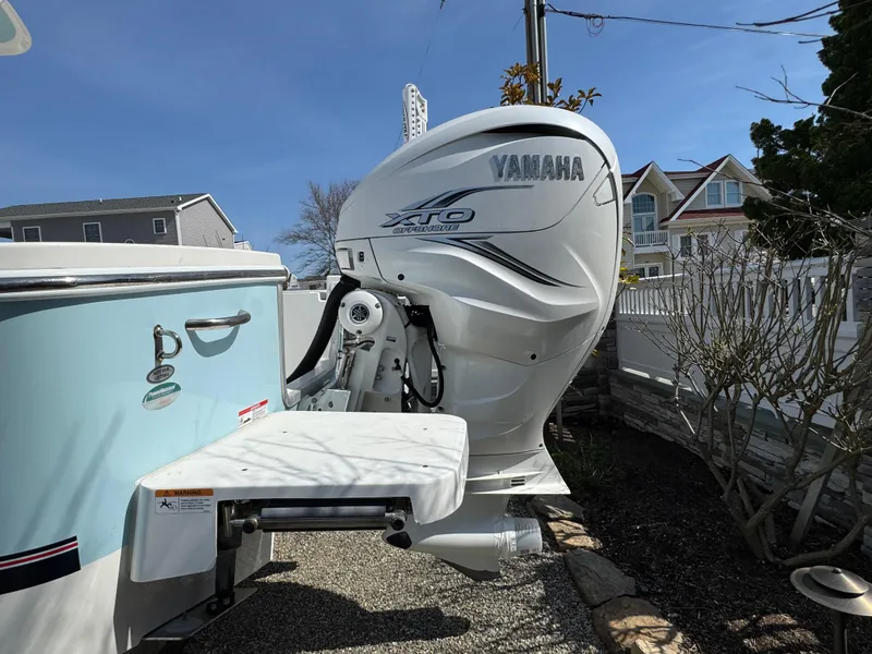 Slide: The Image of 2020 Regulator 26XO with Yamaha XTO outboard motor, parked near residential area. - 11