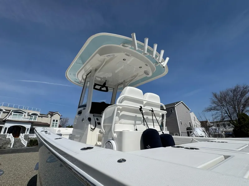 Slide: The Image of 2020 Regulator 26XO boat with T-top and seating, under clear blue sky. - 13