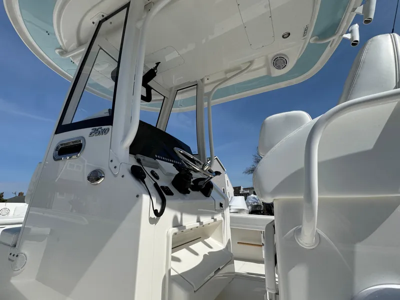 Slide: The Image of 2020 Regulator 26XO boat interior with helm station and seating, under clear blue sky. - 14
