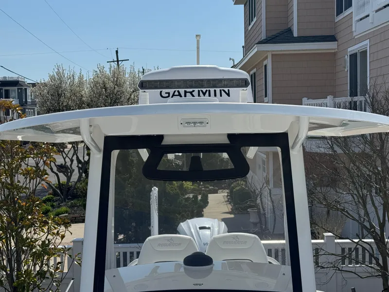 Slide: The Image of 2020 Regulator 26XO boat with Garmin equipment, parked near residential buildings. - 25