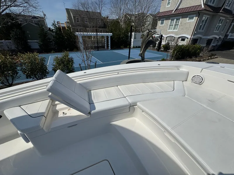 Slide: The Image of 2020 Regulator 26XO boat with white seating, near a tennis court and residential area. - 26