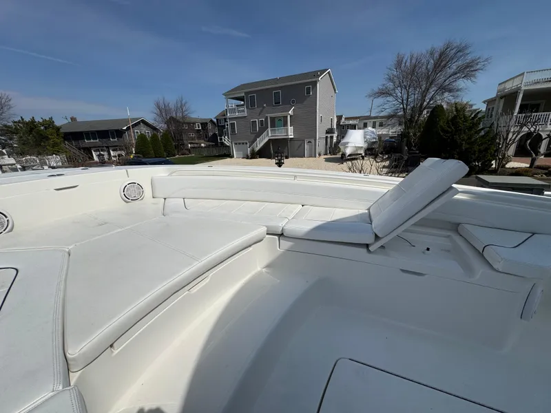 Slide: The Image of 2020 Regulator 26XO boat with spacious white seating area, docked near residential homes. - 27