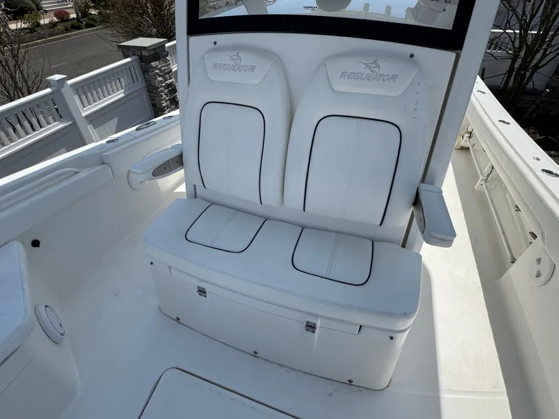 Slide: The Image of 2020 Regulator 26XO boat with white cushioned seating and storage compartment. - 33