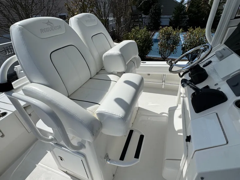 Slide: The Image of 2020 Regulator 26XO boat cockpit with white cushioned seating and steering console. - 41