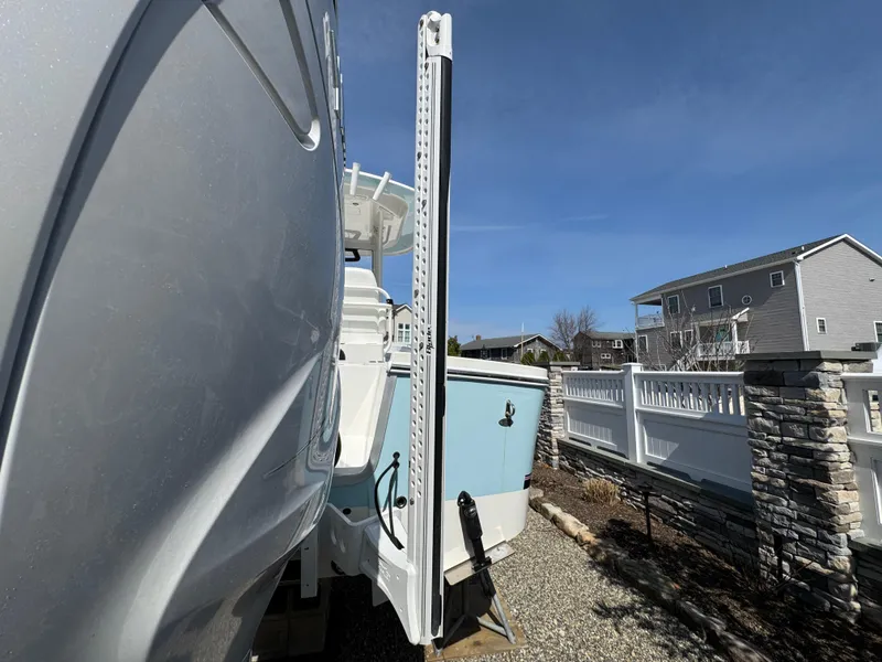 Slide: The Image of 2020 Regulator 26XO boat parked outdoors on gravel, near a white fence and house. - 9