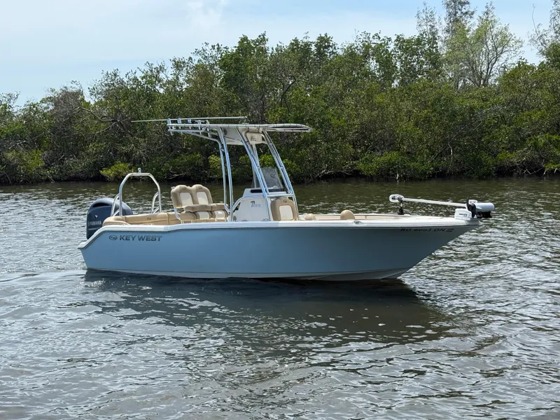 Slide: The Image of 2020 Key West 203 FS boat on calm water near lush greenery. - 0
