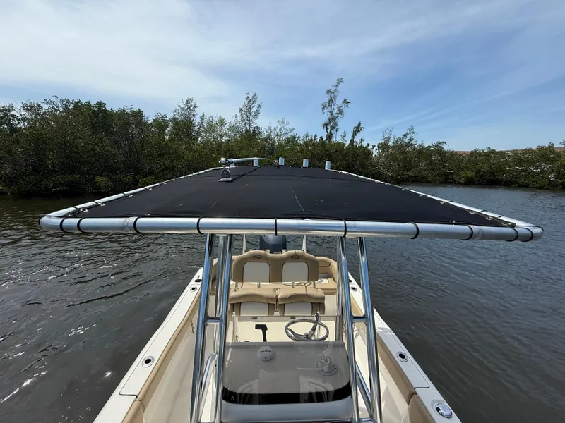 Slide: The Image of 2020 Key West 203 FS boat with T-top on calm water, surrounded by trees. - 13