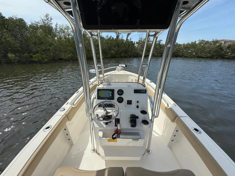 Slide: The Image of 2020 Key West 203 FS boat interior with console, steering wheel, and water view. - 7