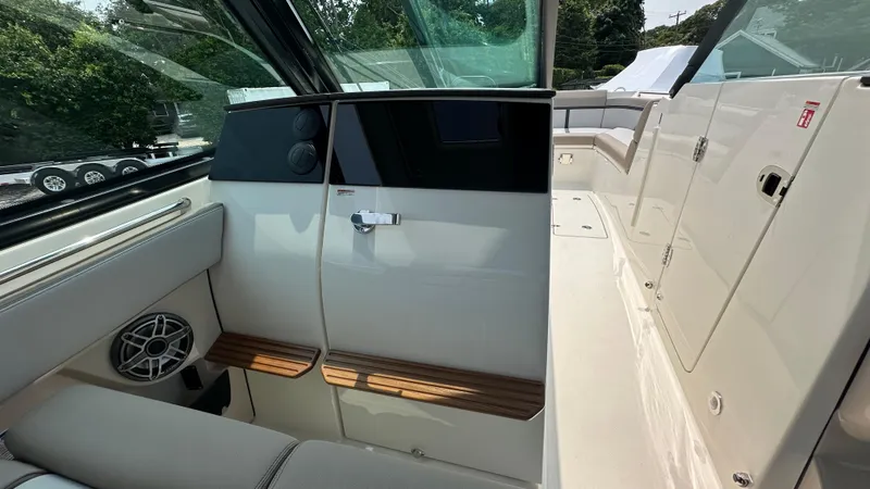 Slide: The Image of 2025 Boston Whaler 330 Vantage interior with seating, speaker, and storage compartments. - 17