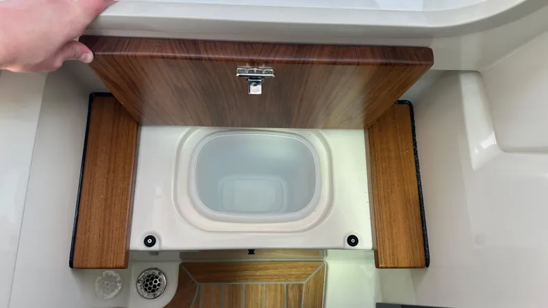 Slide: The Image of 2025 Boston Whaler 330 Vantage boat interior with wooden storage compartment. - 20
