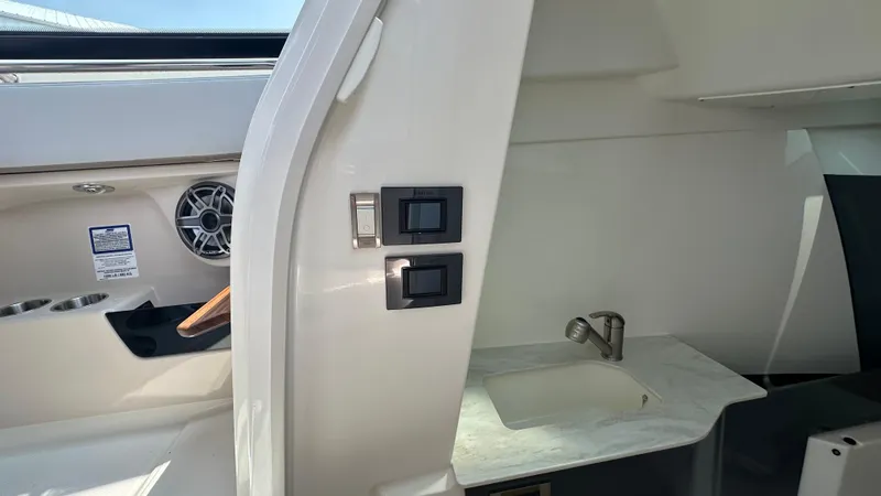 Slide: The Image of Interior of 2025 Boston Whaler 330 Vantage, featuring a sink and control panel. - 22