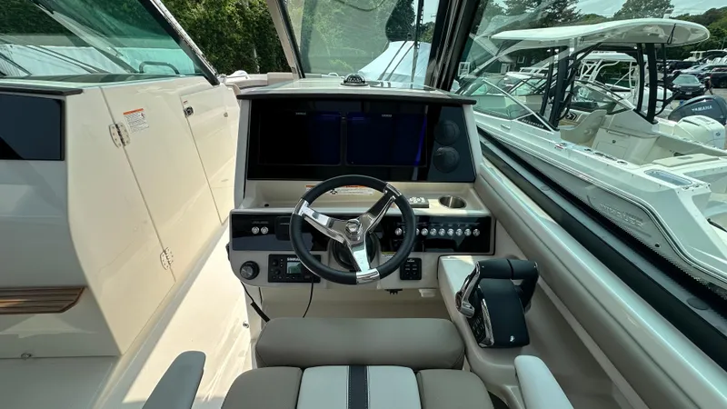 Slide: The Image of 2025 Boston Whaler 330 Vantage helm with modern controls and steering wheel. - 27