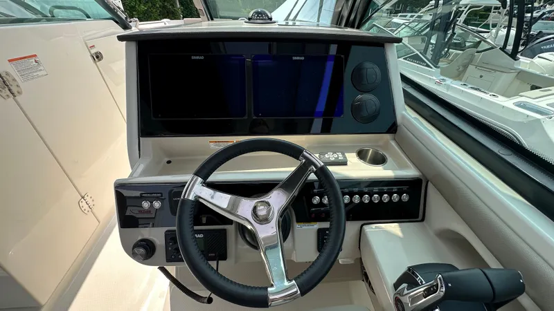 Slide: The Image of 2025 Boston Whaler 330 Vantage helm with steering wheel and control panel. - 28