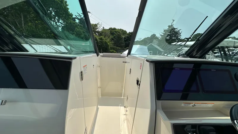 Slide: The Image of 2025 Boston Whaler 330 Vantage boat interior with dual consoles and glass windshields. - 32