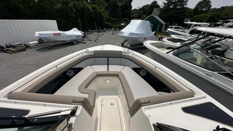 Slide: The Image of 2025 Boston Whaler 330 Vantage boat with spacious seating in a marina setting. - 35