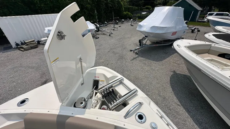 Slide: The Image of 2025 Boston Whaler 330 Vantage boat with open storage compartment in a gravel lot. - 38