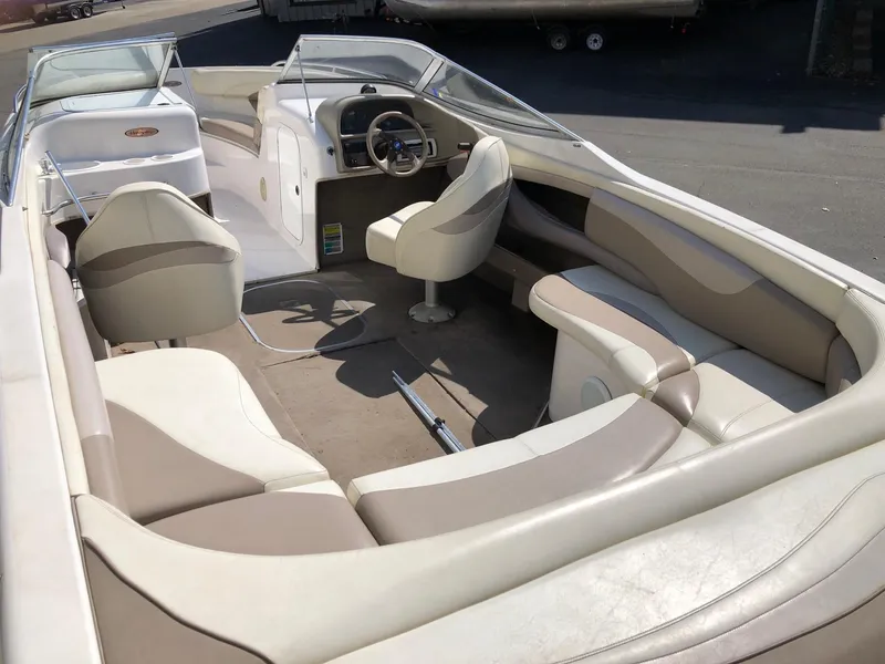 Slide: The Image of 1997 Four Winns 240 Horizon boat interior with beige seating and steering console. - 2