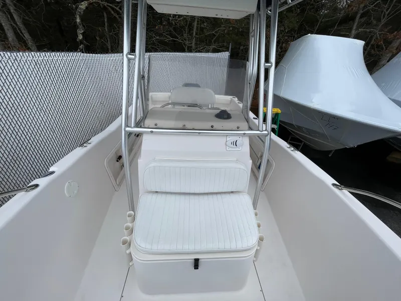 Slide: The Image of 1999 Grady-White 209 ESCAPE boat interior with seating and console, docked near a fence. - 10