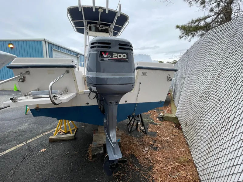 Slide: The Image of 1999 Grady-White 209 ESCAPE boat with V6 200 outboard motor, parked outdoors. - 18