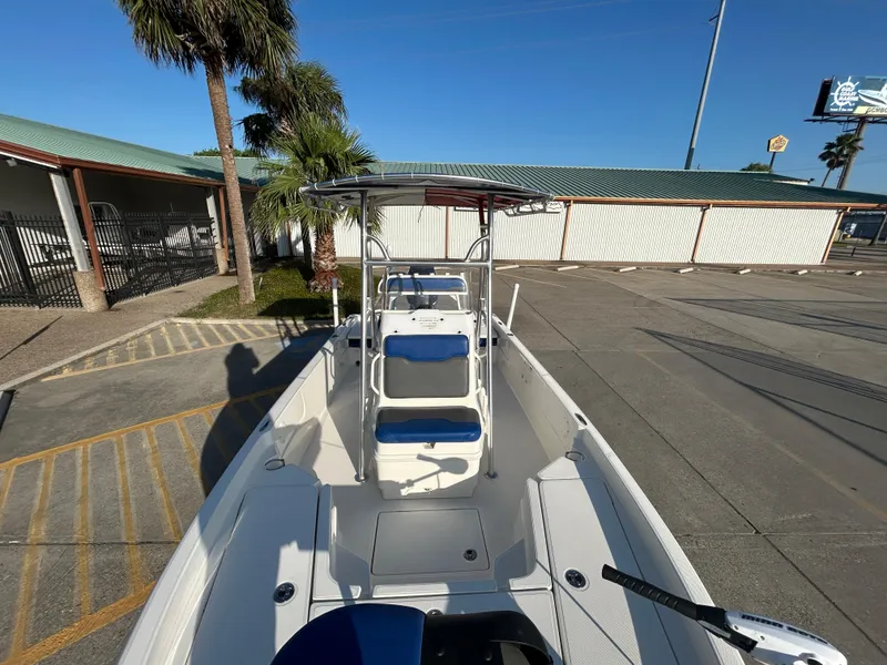 Slide: The Image of 2016 Skeeter SX 210 boat with blue seats, parked outdoors near palm trees. - 13