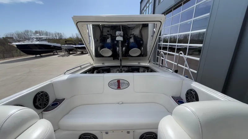 Slide: The Image of 1993 Cigarette 38 Top Gun boat with open engine compartment, white seating, and docked nearby. - 11