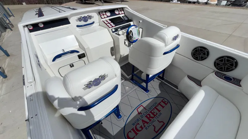 Slide: The Image of 1993 Cigarette 38 Top Gun boat interior with white and blue seating, dashboard, and logo. - 14
