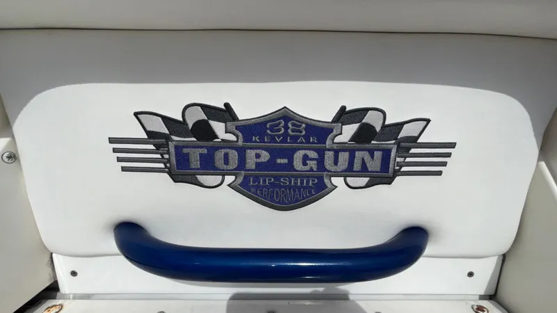 Slide: The Image of 1993 Cigarette 38 Top Gun logo with checkered flags and blue handle. - 26