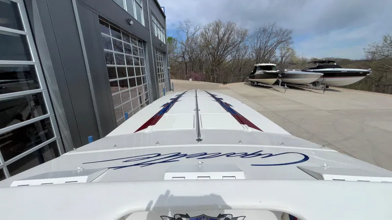 Slide: The Image of 1993 Cigarette 38 Top Gun boat parked near a garage with other boats in the background. - 27