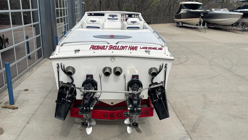 Slide: The Image of 1993 Cigarette 38 Top Gun boat with dual engines, parked outdoors near other boats. - 5