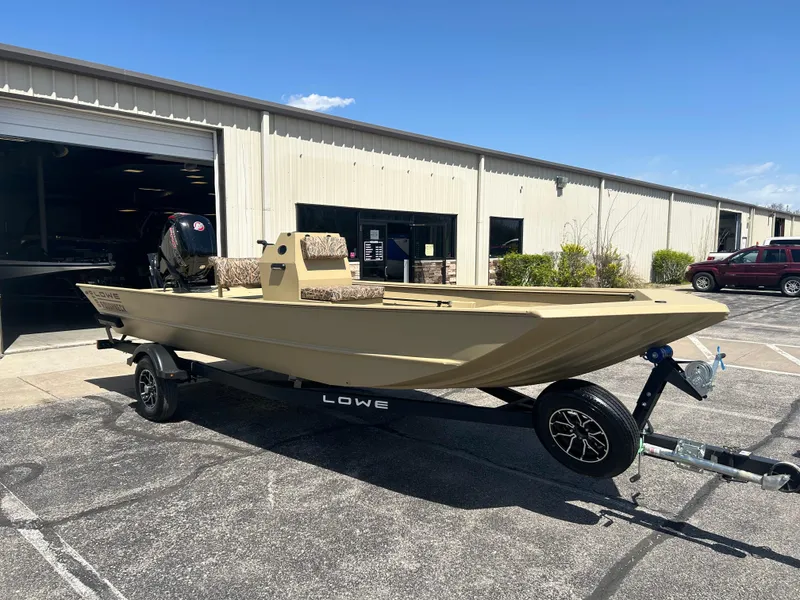 Slide: The Image of 2025 Lowe Roughneck 2070 CC boat on trailer outside a warehouse. - 2