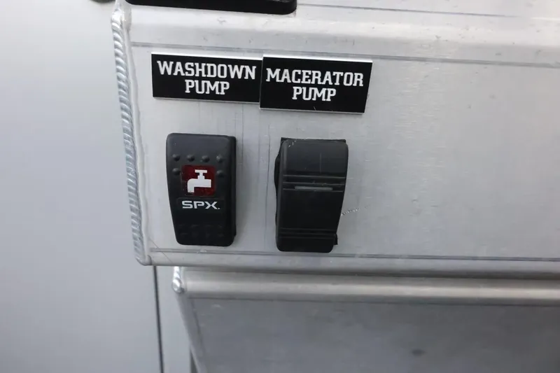 Slide: The Image of Control panel with washdown and macerator pump switches on a 2015 Duckworth 26 Offshore boat. - 24