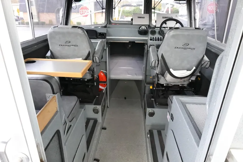 Slide: The Image of 2015 Duckworth 26 Offshore boat interior with seating, steering wheel, and control panel. - 26