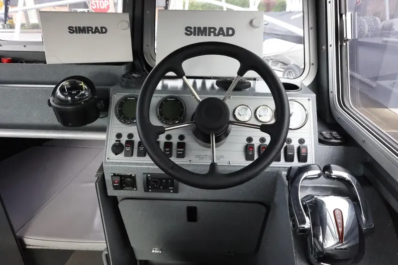 Slide: The Image of 2015 Duckworth 26 Offshore boat dashboard with Simrad navigation system and steering wheel. - 34